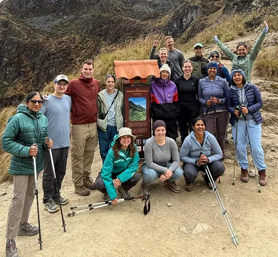 Group of trekkers posing together at a high-altitude mountain pass on the classic Inca Trail